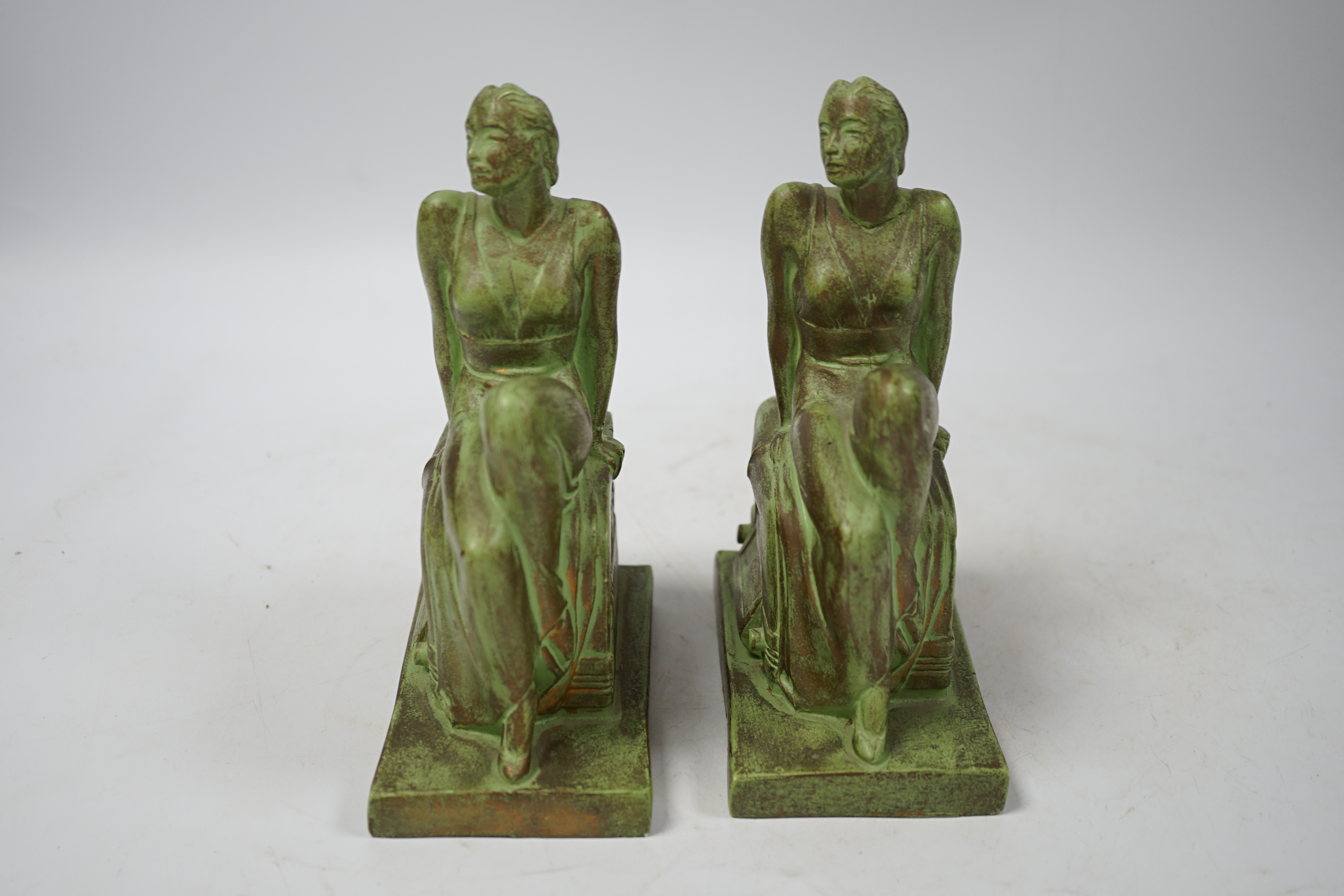 A pair of Art Deco RCA Victor bronzed ceramic ‘chalkwear’ bookends, in the form of a woman sitting on a 1930s radio, produced for the 1939 New York World Fair to promote the RCA Victor record label, 17cm high